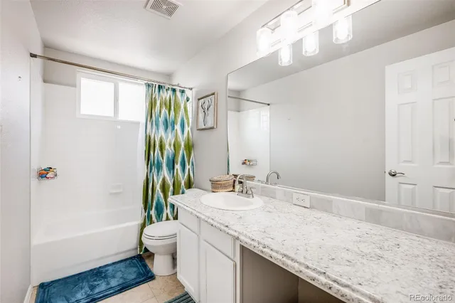 a bathroom with a granite countertop sink a toilet and bathtub