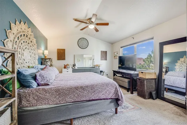 a bedroom with a bed a chandelier and dresser