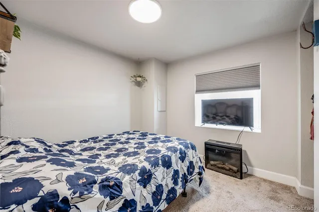 a living room with a bed and flat screen tv