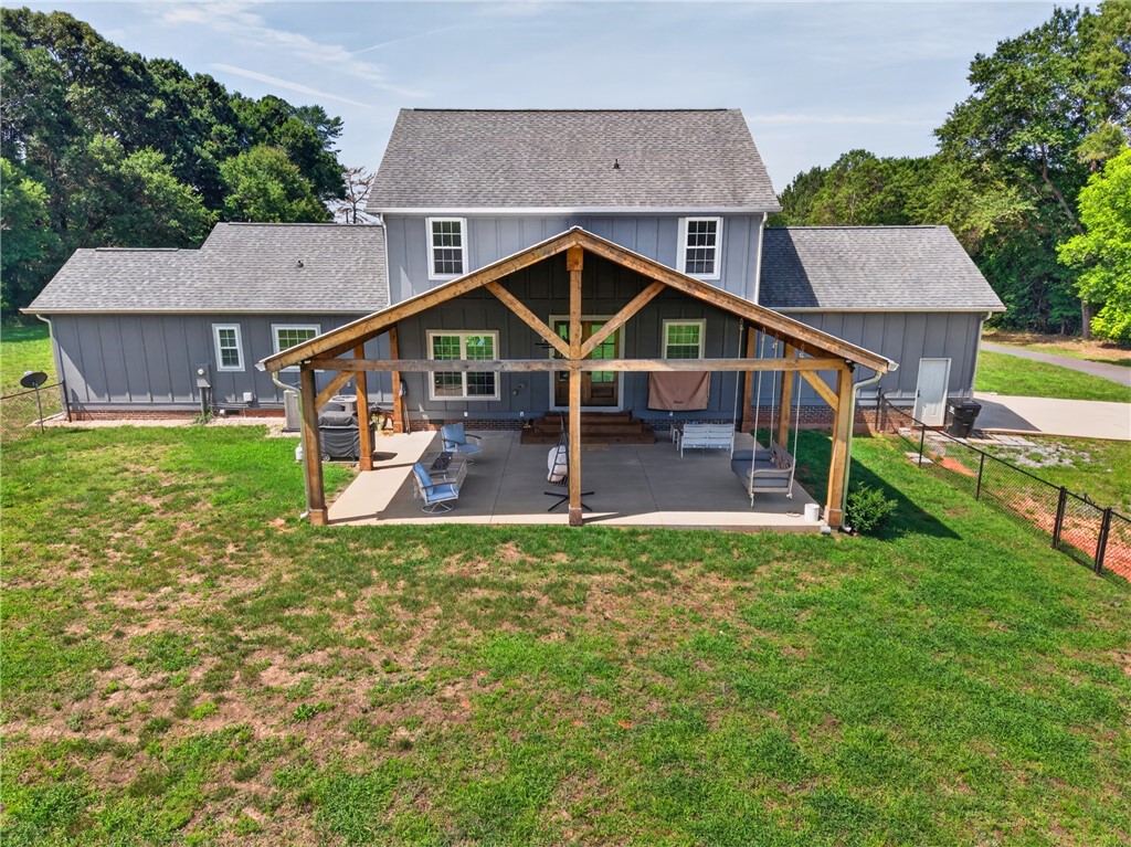 5016 Copeland Road Belton, SC 29627 - Photo 2 of 45 An inviting covered patio offers ample space for outdoor enjoyment, overlooking a green backyard.
