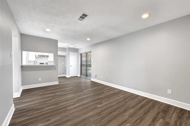 a view of a hallway with wooden floor and a cabinet