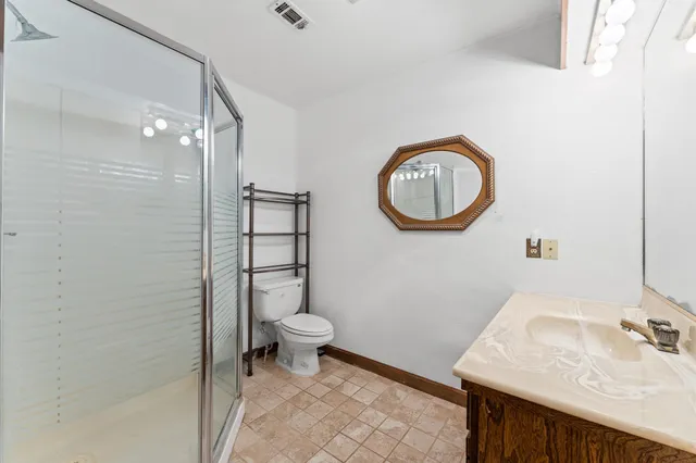 a bathroom with a granite countertop sink a toilet and a mirror