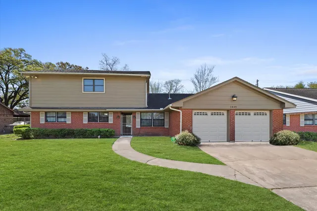 a view of house with a big yard and potted plants