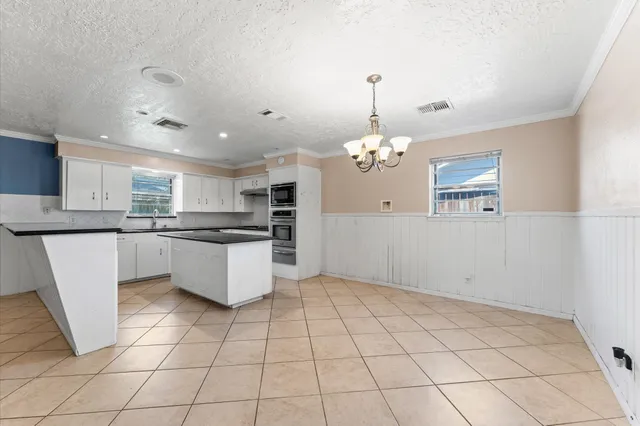 a large kitchen with kitchen island granite countertop a stove a sink and a refrigerator