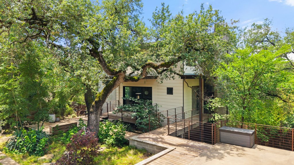 801 The High Road Austin, TX 78746 - Photo 38 of 40 a front view of a house with a yard garage and outdoor seating