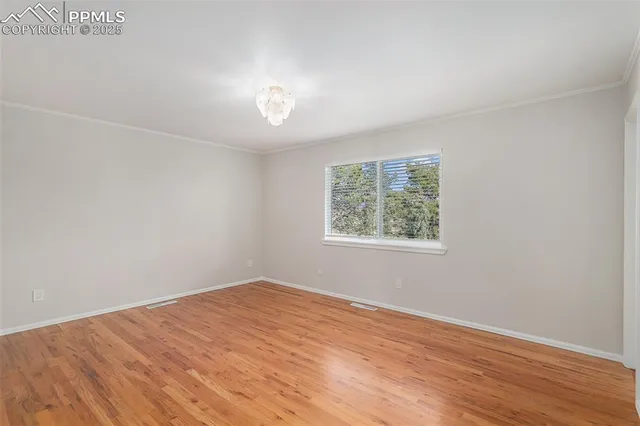 an empty room with wooden floor and window