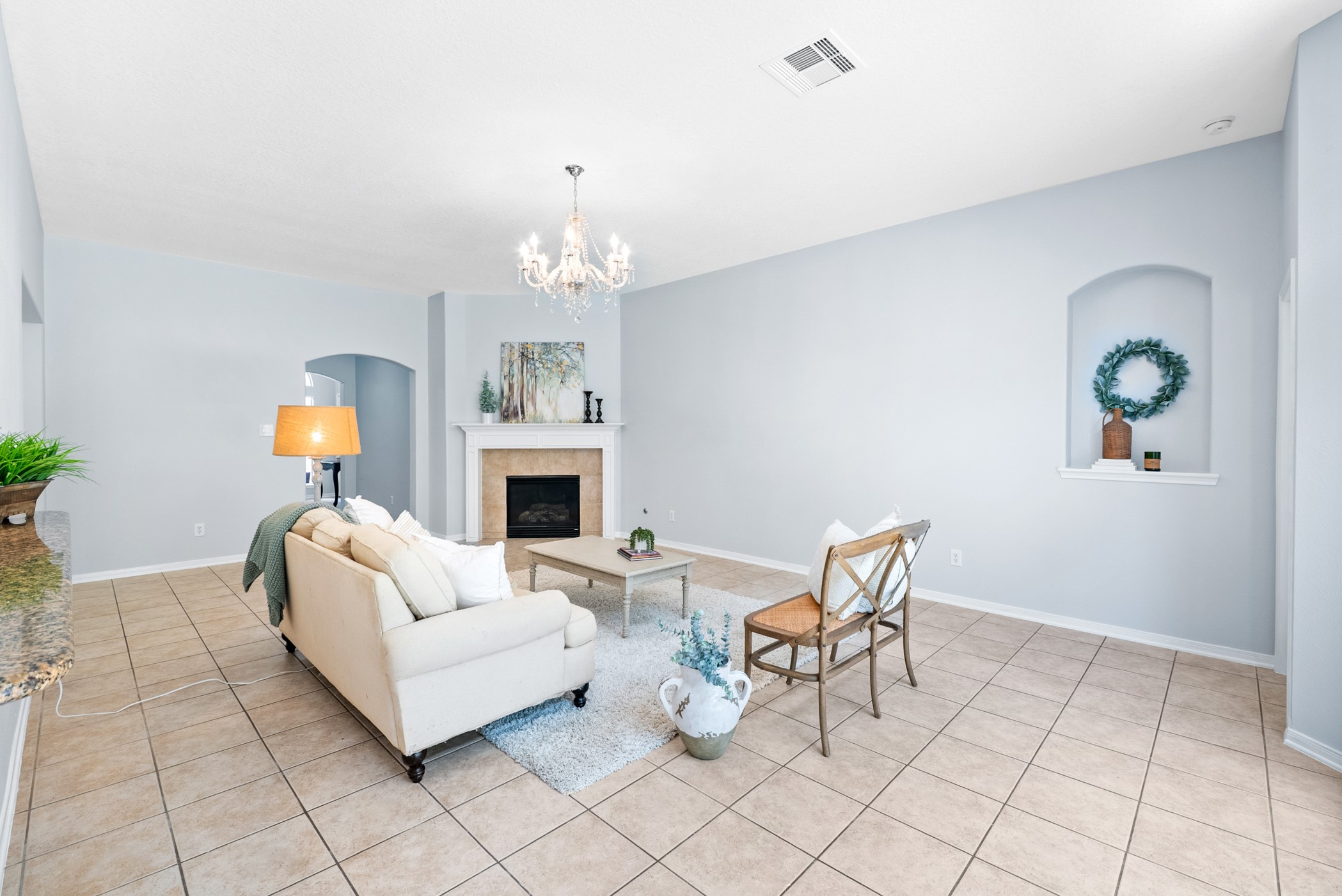 2914 Intrepid Elm Street Houston, TX 77084 - Photo 7 of 32 a living room with furniture a fireplace and chandelier