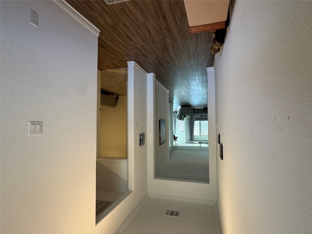 2005 Long Shadow Lane Georgetown, TX 78628 - Photo 3 of 21 Hallway with dark wood-style floors, a textured wall, and crown molding