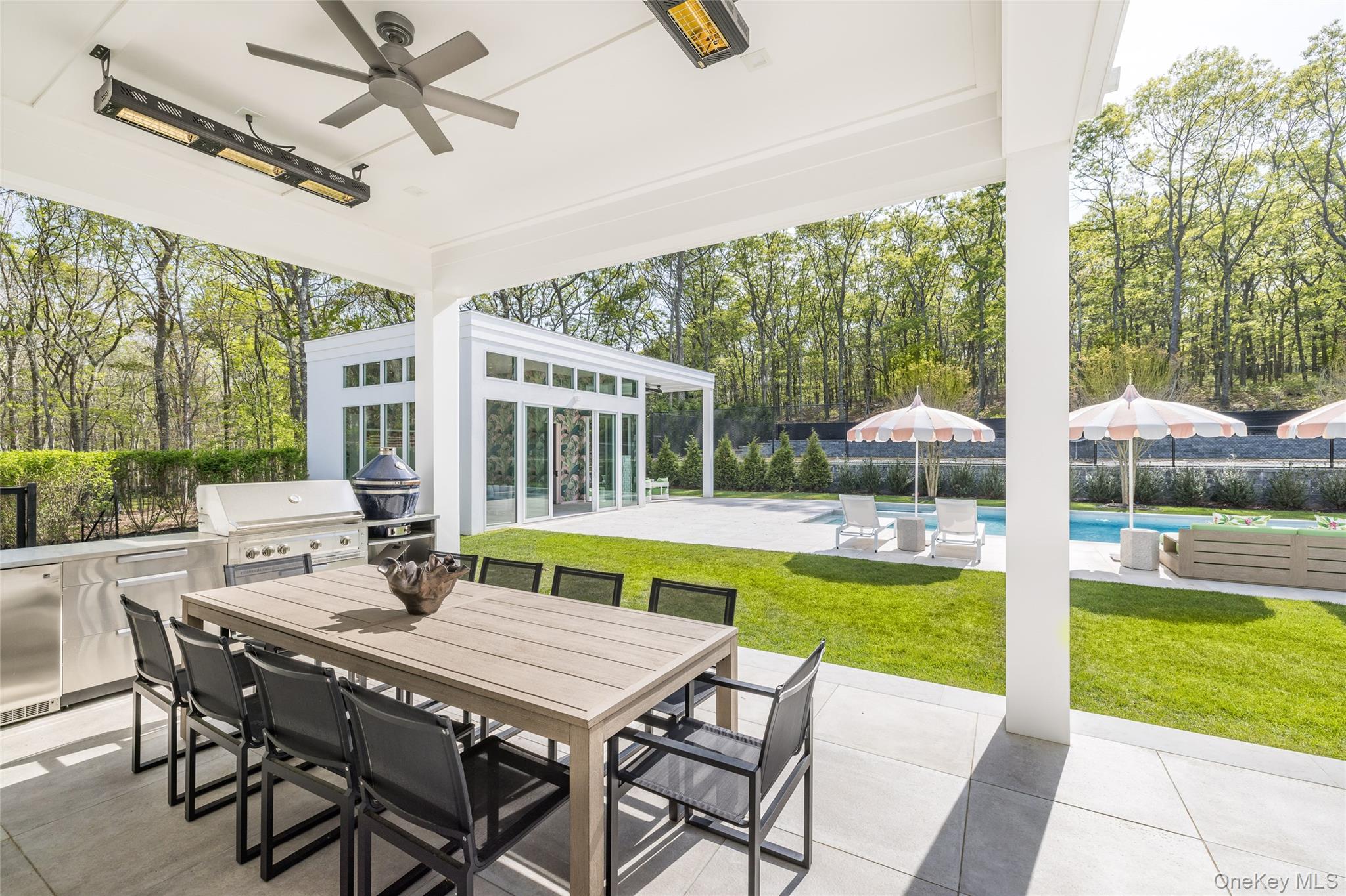 1552 Deerfield Road Water Mill, NY 11976 - Photo 7 of 37 a view of a patio with a table chairs and a swimming pool