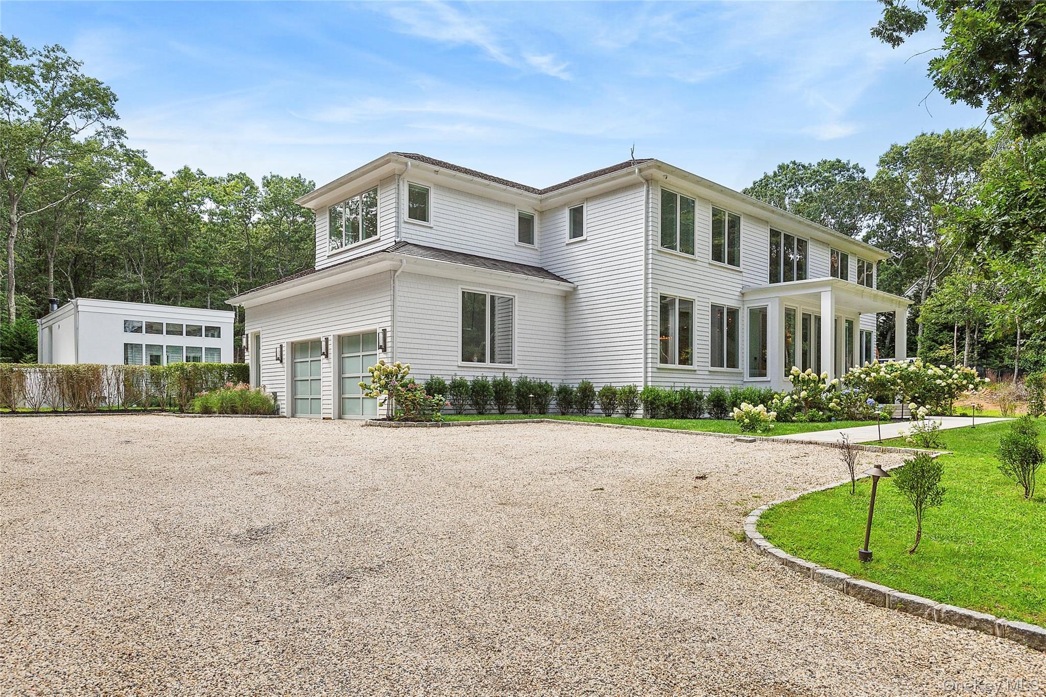 1552 Deerfield Road Water Mill, NY 11976 - Photo 9 of 37 a front view of a house with a yard and garage