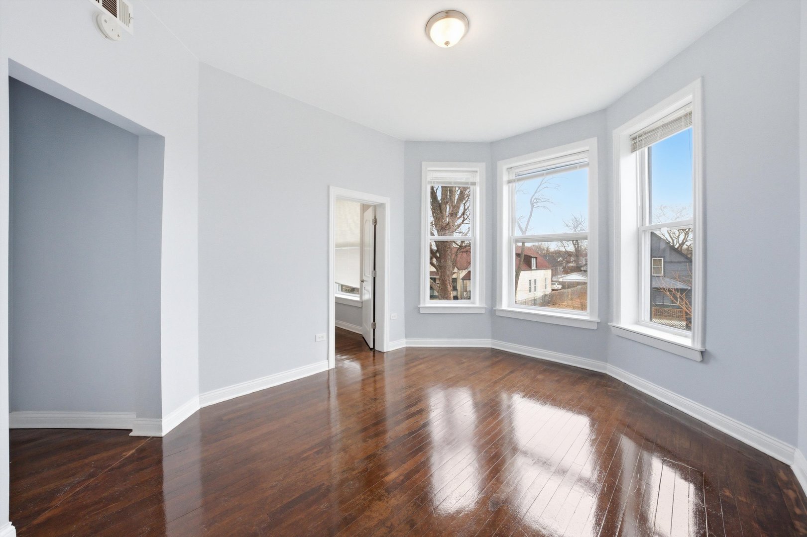 7242 South May Street, Unit 2 Chicago, IL 60621 - Photo 4 of 12 a view of an empty room with wooden floor and a window