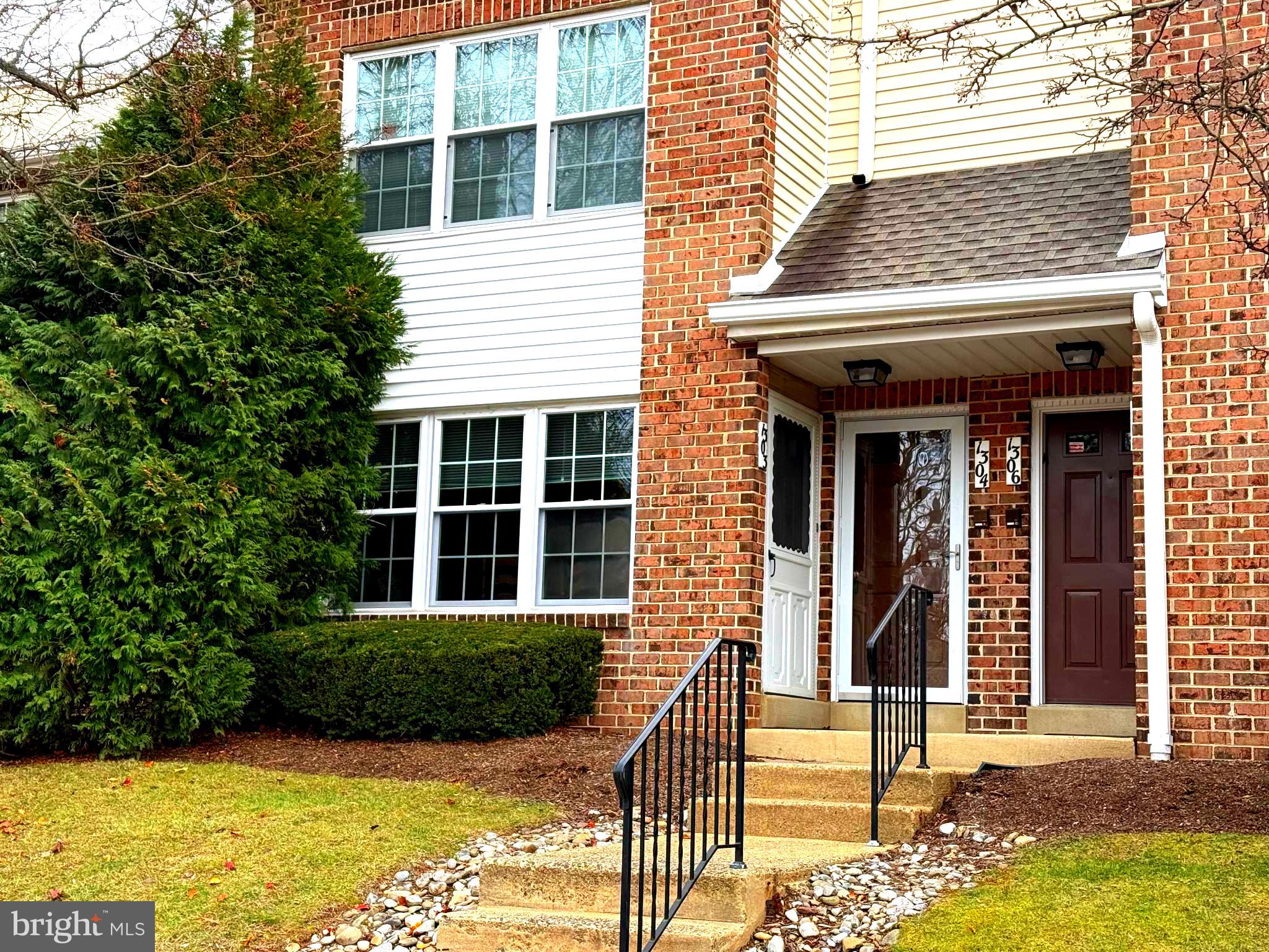 a view of a brick house with plants and large windows