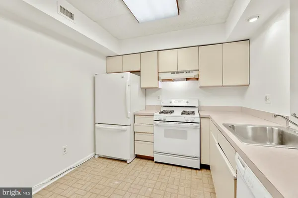 a kitchen with a stove a refrigerator and a sink