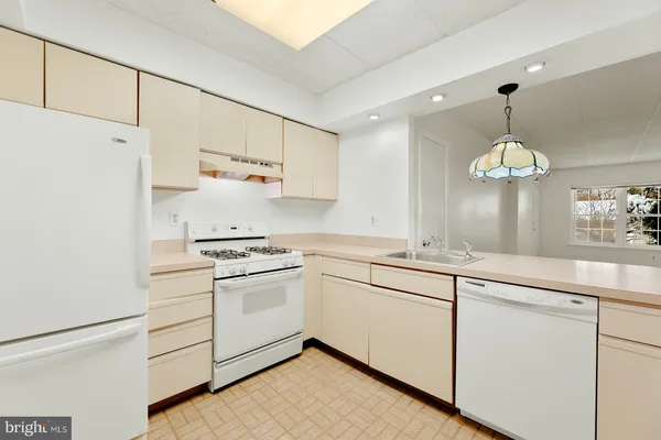 a kitchen with cabinets stainless steel appliances and a chandelier