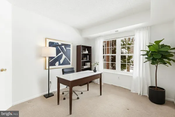a view of a workspace with furniture and a window