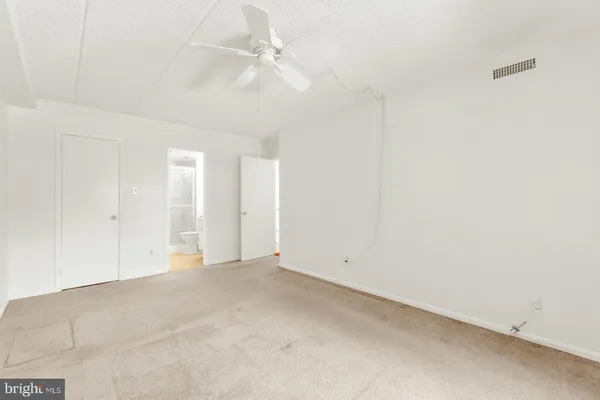 an empty room with a ceiling fan and a window