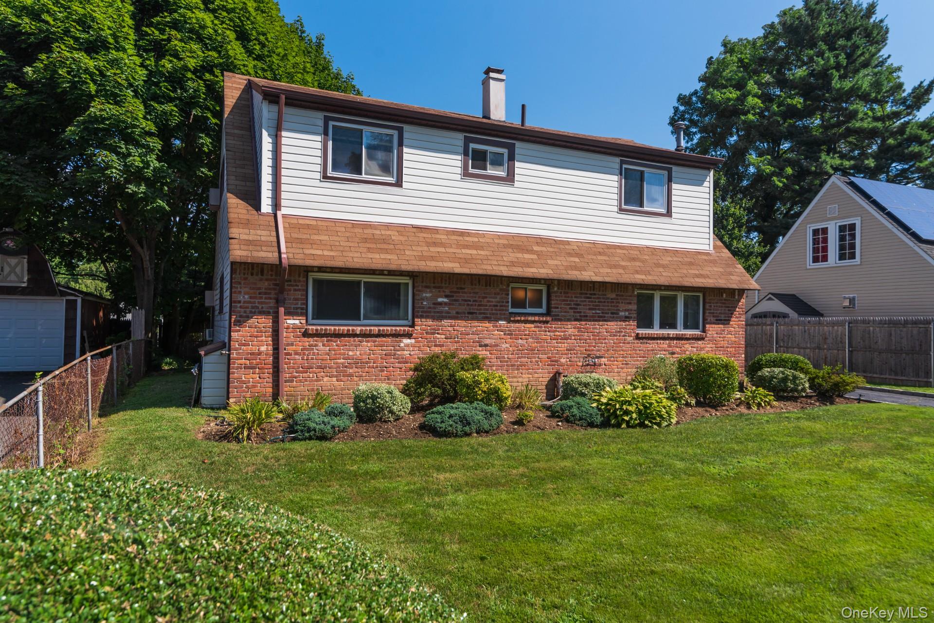 27 Collins Road Glen Cove, NY 11542 - Photo 2 of 13 front view of a house with a yard