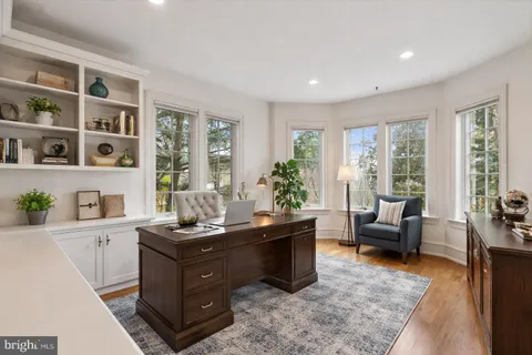 a room with a couch bookshelf and a window