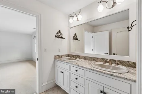 a bathroom with a granite countertop sink and a mirror
