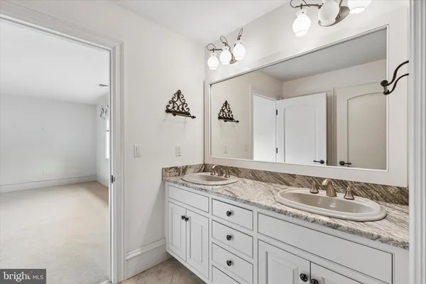 a bathroom with a granite countertop sink and a mirror