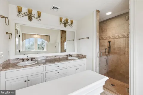 a bathroom with a granite countertop sink mirror and shower