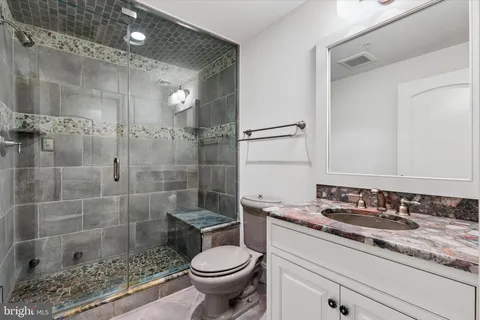 a bathroom with a sink a toilet and shower