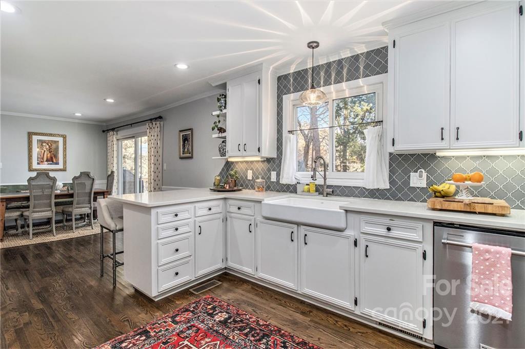 3513 Highview Road Charlotte, NC 28210 - Photo 10 of 27 a kitchen with granite countertop a stove a sink and white cabinets with wooden floor