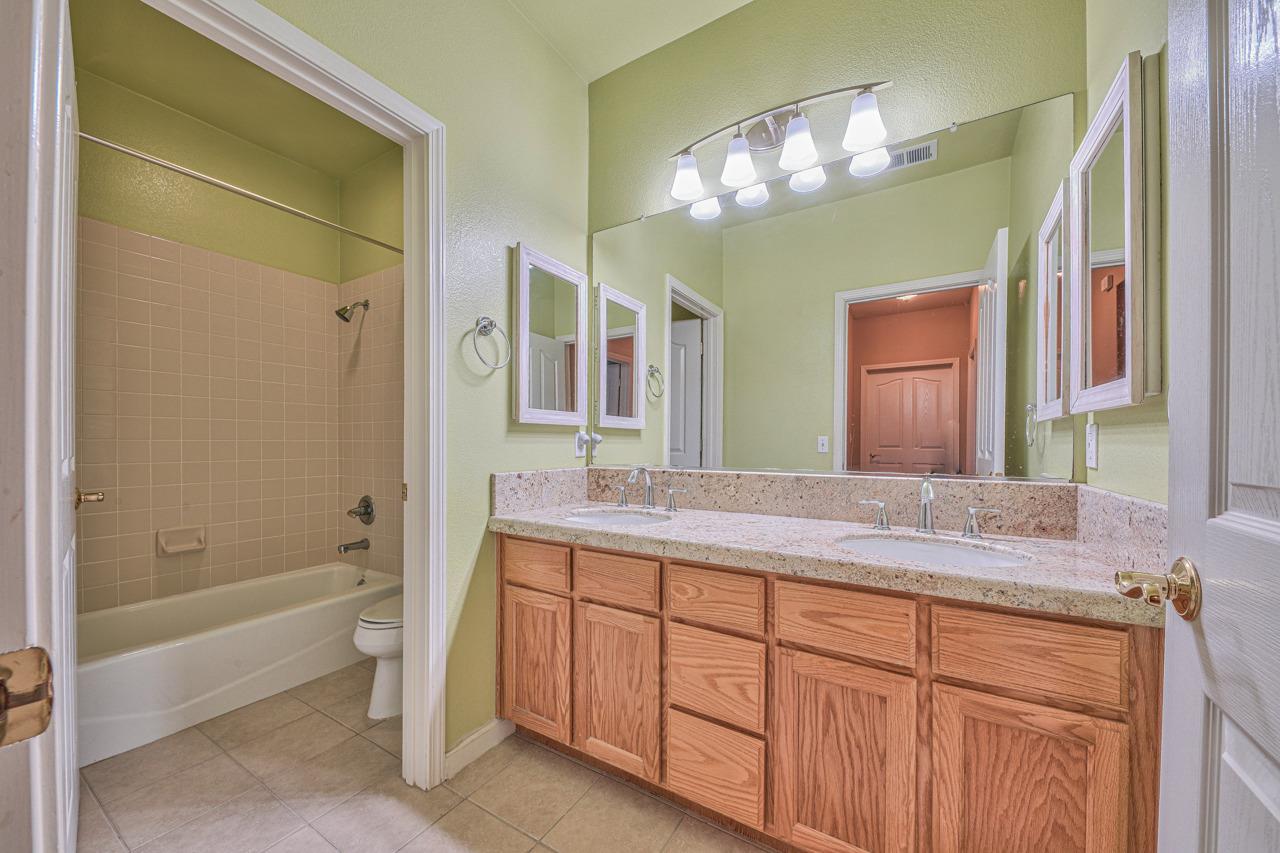 20 Glen Falls Circle Salinas, CA 93906 - Photo 33 of 37 a bathroom with a granite countertop sink a toilet and a bathtub