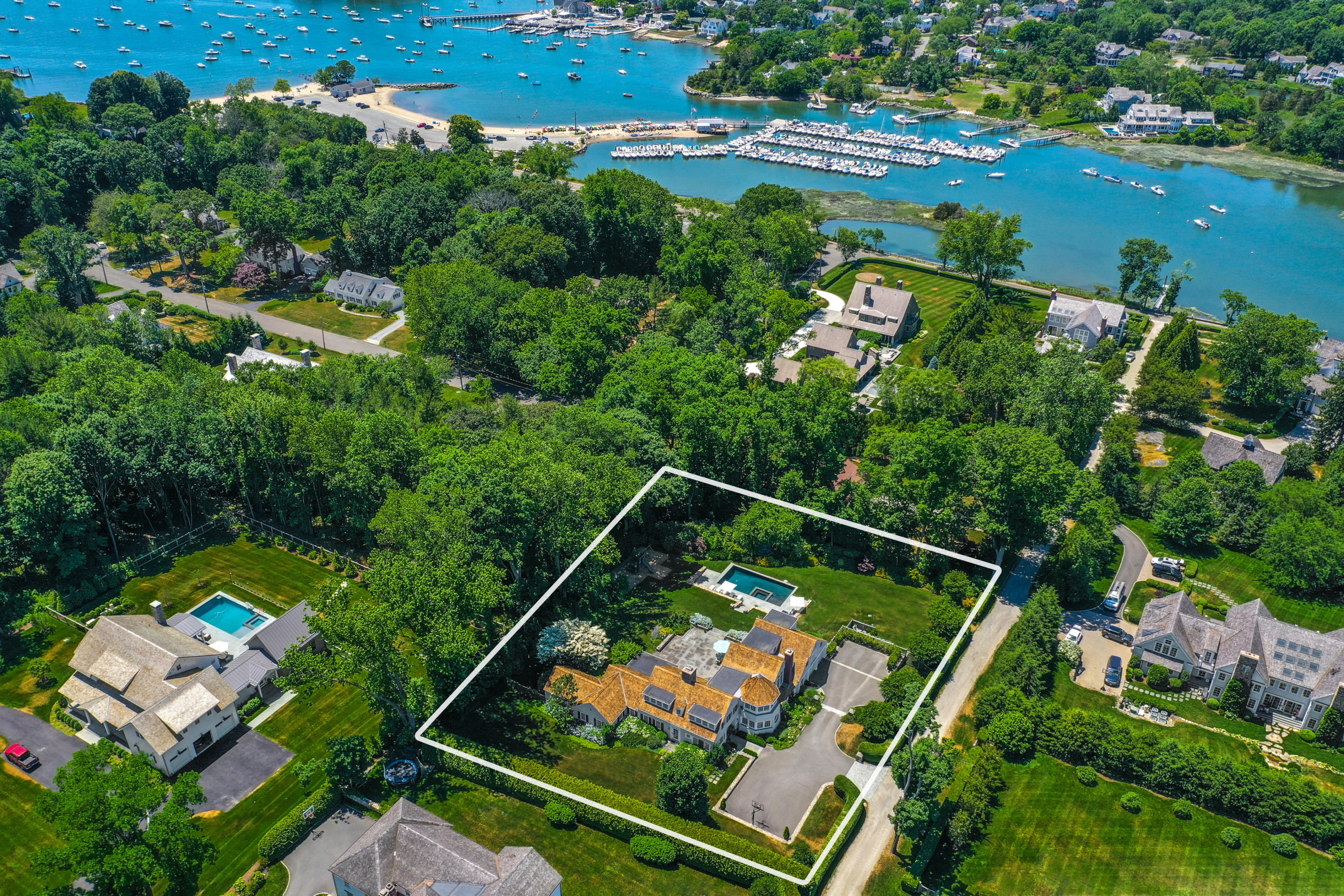 an aerial view of a tennis ground and a cars park side of the road