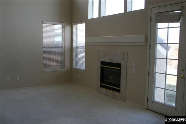 9590 Apache Rose Drive Reno, NV 89521 - Photo 3 of 9 an empty room with windows and fireplace