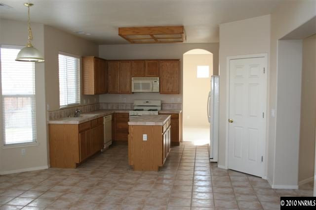9590 Apache Rose Drive Reno, NV 89521 - Photo 5 of 9 a kitchen with a stove a sink and a refrigerator