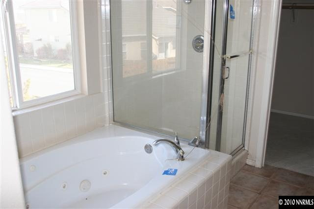 9590 Apache Rose Drive Reno, NV 89521 - Photo 7 of 9 a bathroom with a tub and shower