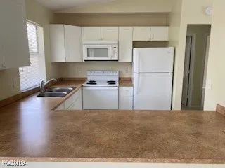 a kitchen with a refrigerator a stove a microwave a sink and cabinets