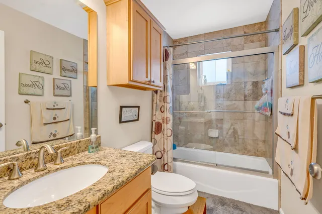 a bathroom with a granite countertop sink toilet and shower