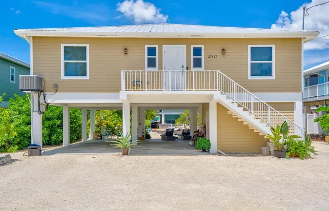 front view of a building with potted plants and a parking space