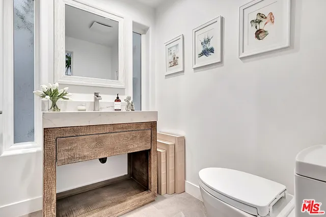 a bathroom with a sink a toilet and mirror