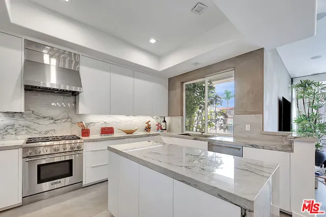 a kitchen with stainless steel appliances granite countertop a sink stove and cabinets