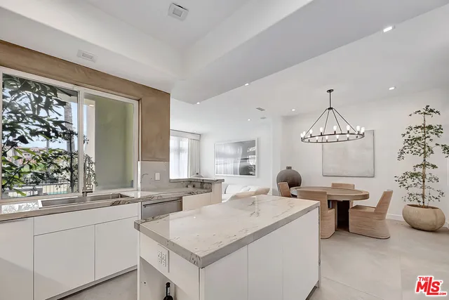 a large white kitchen with a window and a sink