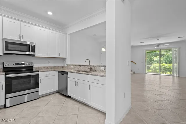 a kitchen with granite countertop a stove a sink and a microwave