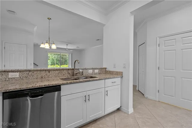 a kitchen with a sink dishwasher and white cabinets