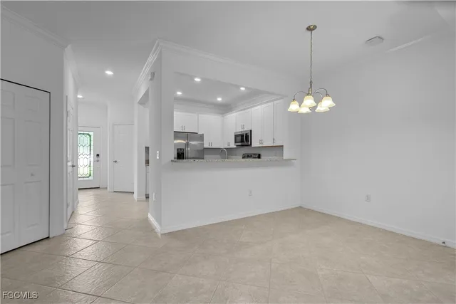 a view of a kitchen with refrigerator and a chandelier