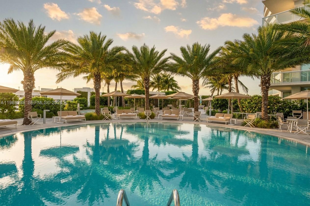 450 Alton Road, Unit 1202 Miami Beach, FL 33139 - Photo 30 of 68 a view of swimming pool with table and chairs water fall and palm tree