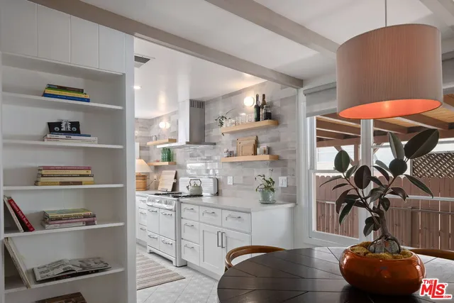 a kitchen with stainless steel appliances cabinets and a chair