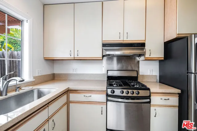a kitchen with stainless steel appliances granite countertop a sink stove and cabinets