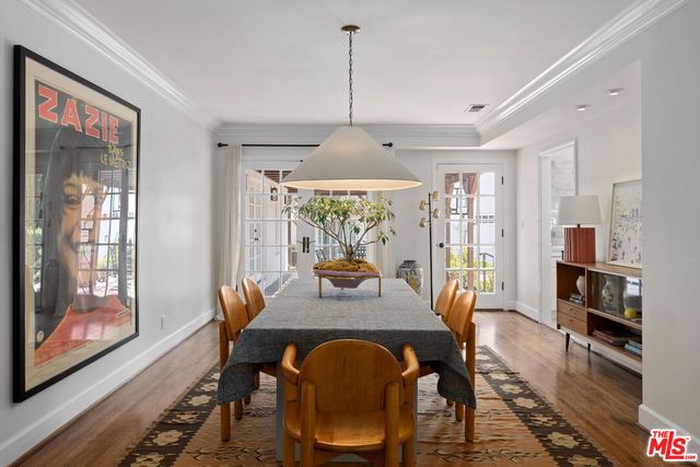 a dining room with furniture a chandelier and wooden floor
