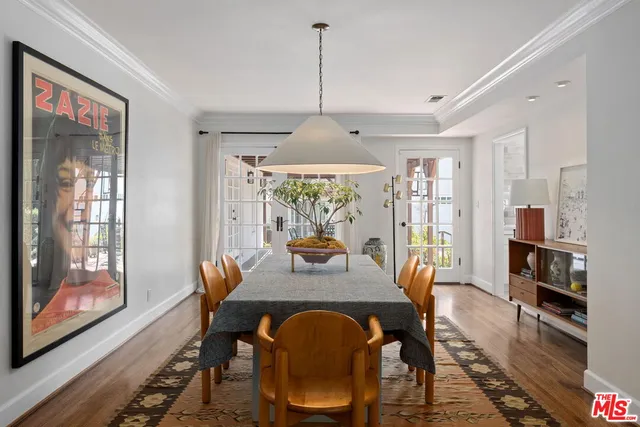 a dining room with furniture a chandelier and wooden floor