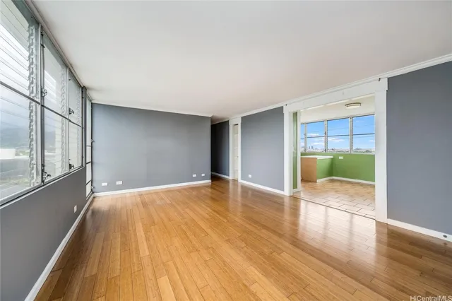 a view of empty room with wooden floor and fan
