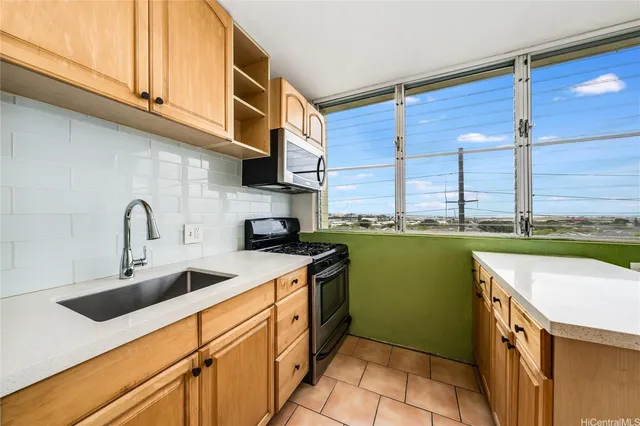 a kitchen with kitchen island granite countertop a sink a counter top space and cabinets