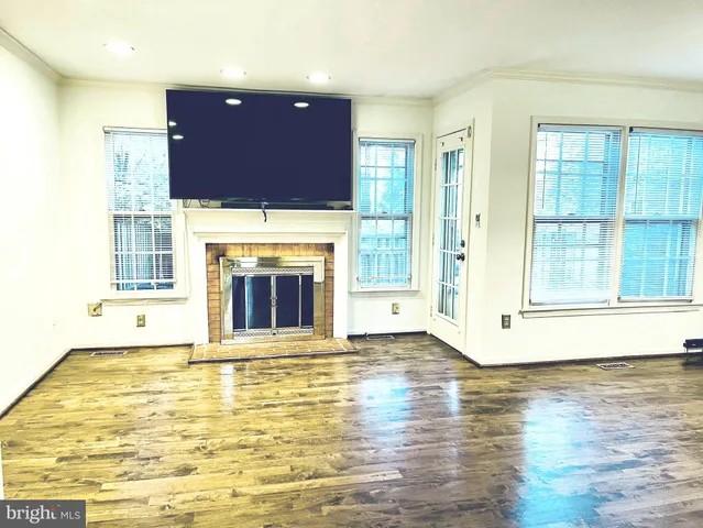 a view of empty room with wooden floor and fireplace