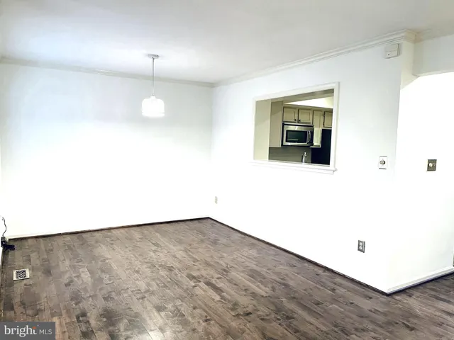 an empty room with wooden floor and mirror